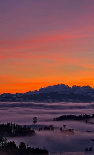 Mgła nad górzystą doliną i zachód słońca