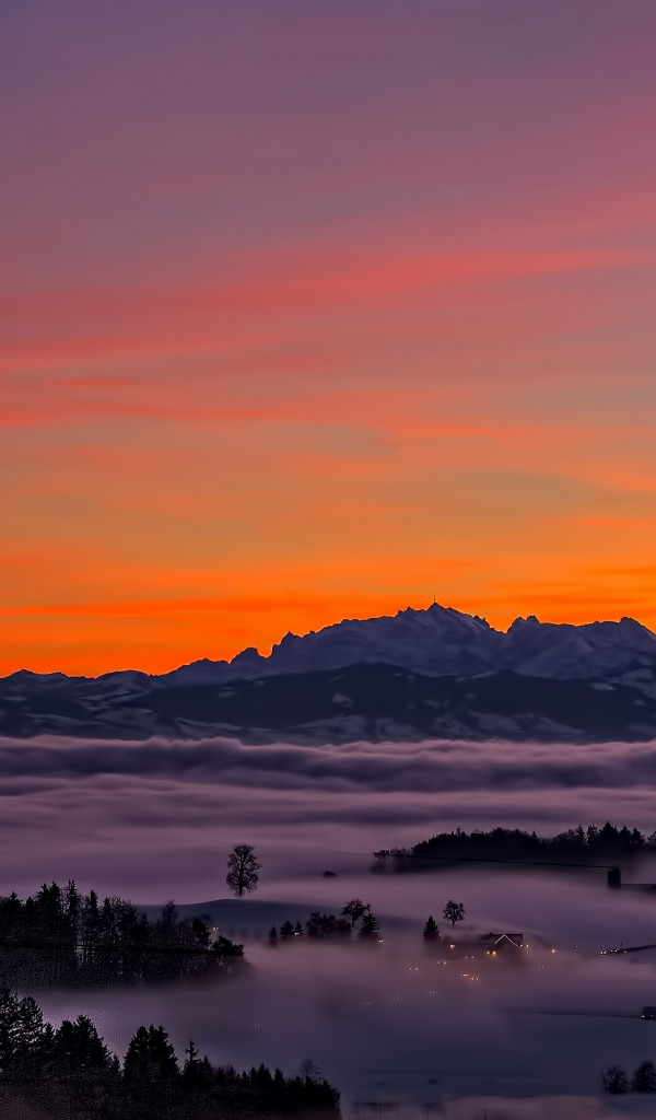 Mgła nad górzystą doliną i zachód słońca